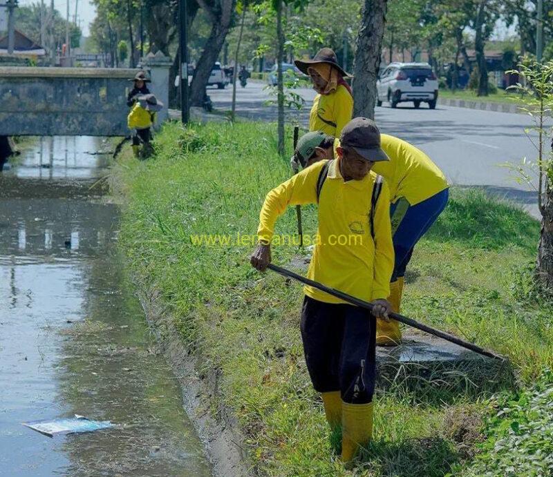 Pasukan Kuning PUPR Kota Pekanbaru melakukan pembersihan saluran drainase - Pekanbaru.