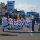 Massa aksi membentang spanduk bertuliskan